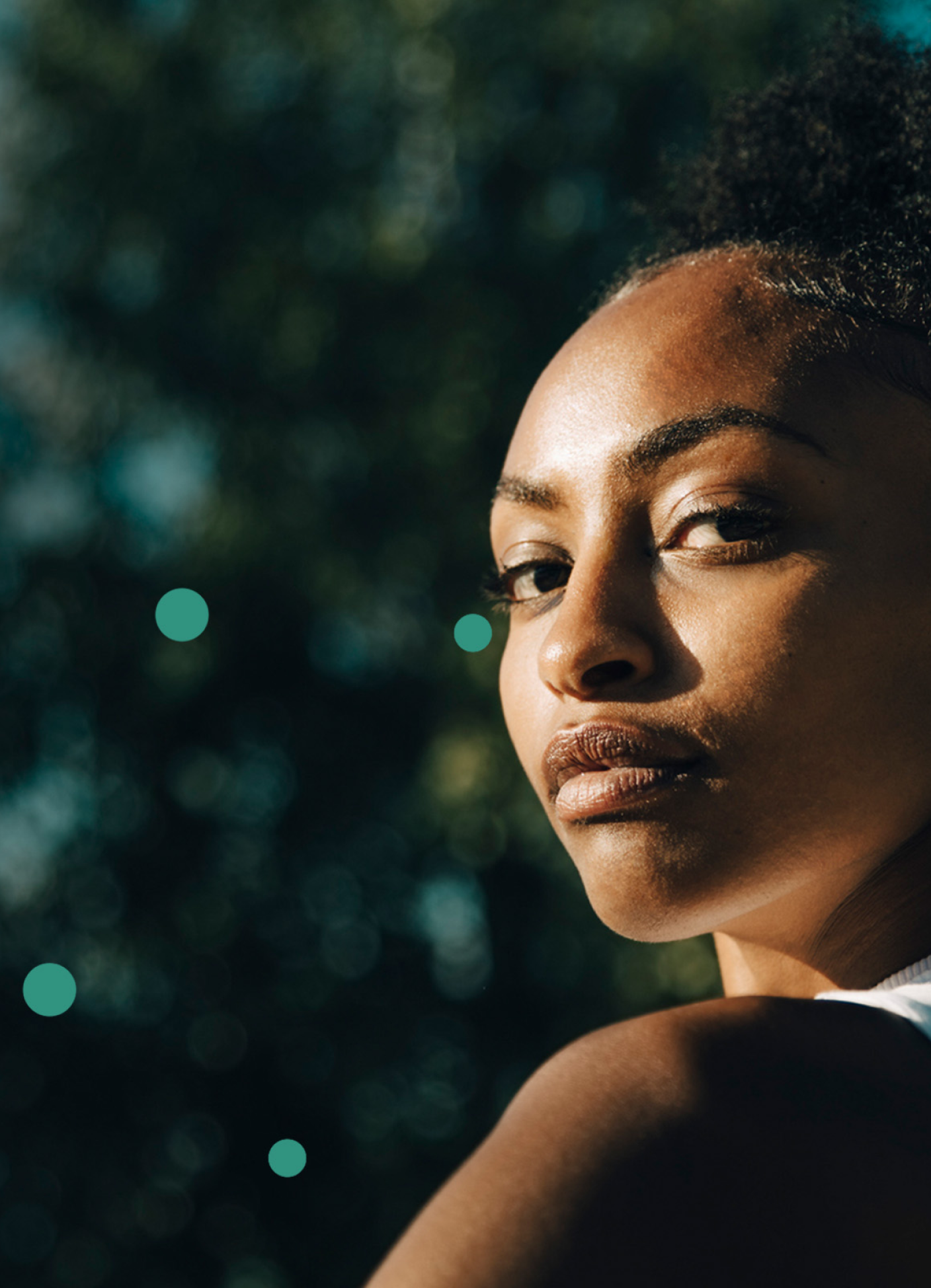 Confident woman in sunlight with teal dots, representing Neurobiologix wellness.